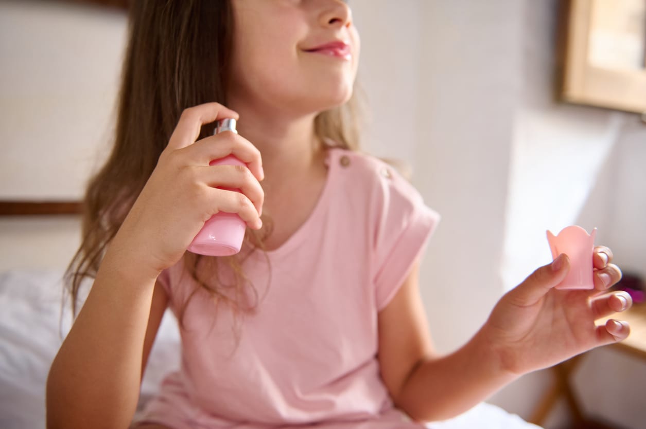 Young girl smiling while applying perfume, enjoying scent Naturliches Parfum Fur Kinder Lilie &Amp; Lotus